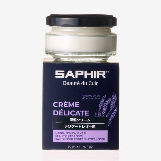 紺色の箱の上に置いたサフィールのデリケートクリーム。白い中身が見える丸い瓶と黒いふた