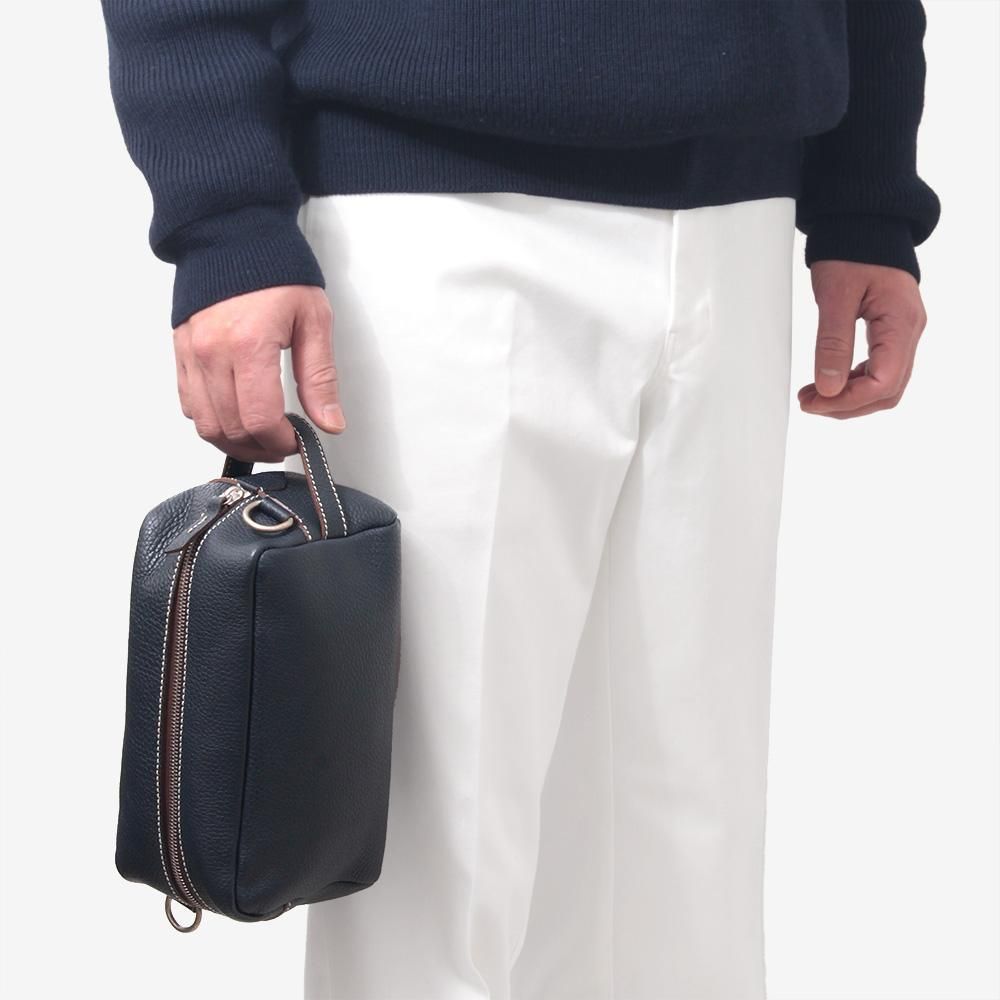 TROUSSE TOILETTEボディバッグを短いハンドルで手持ちした使用例。ショルダーストラップを外した状態