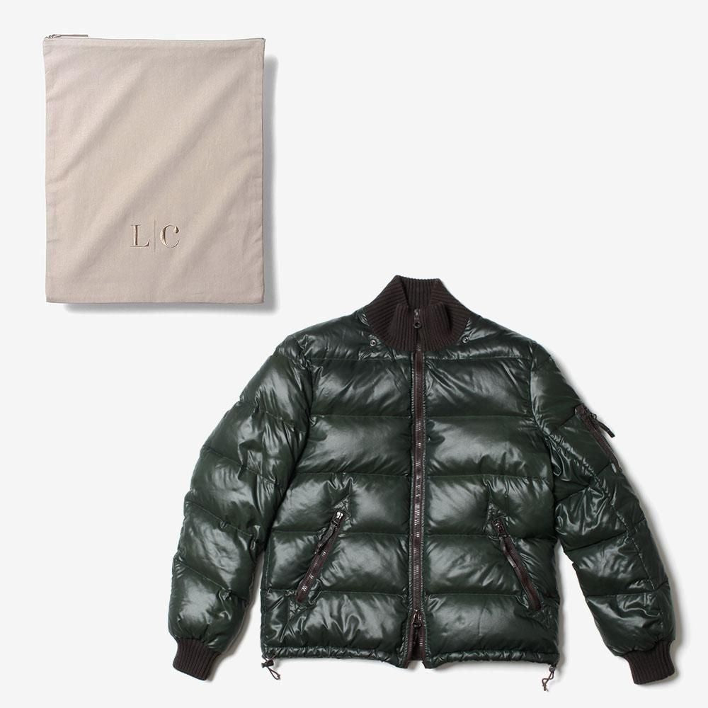 淡いベージュのLCストレージバッグと濃緑のダウンジャケットを平らに並べた大きさの比較