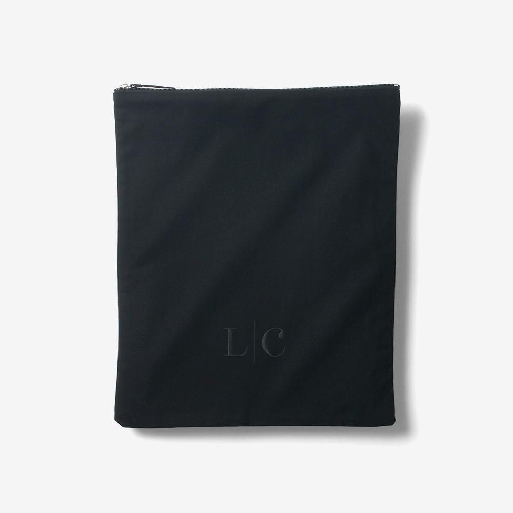 LCストレージバッグMの黒いモデル。平らに広げた四角い本体と上部のファスナー