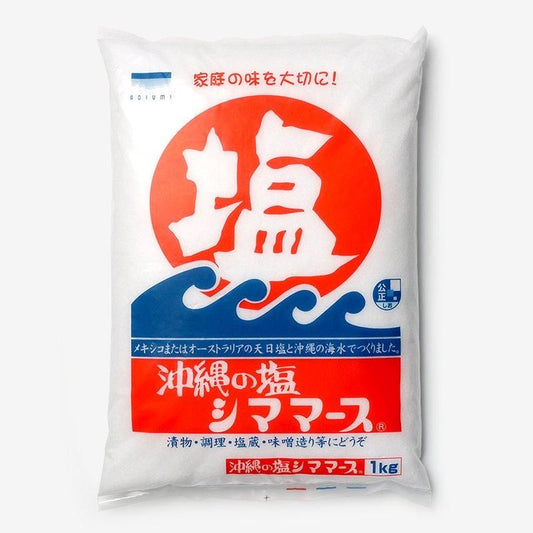 沖縄の塩シママース1kg。白い袋に赤い丸と大きな塩の文字、青い波の絵