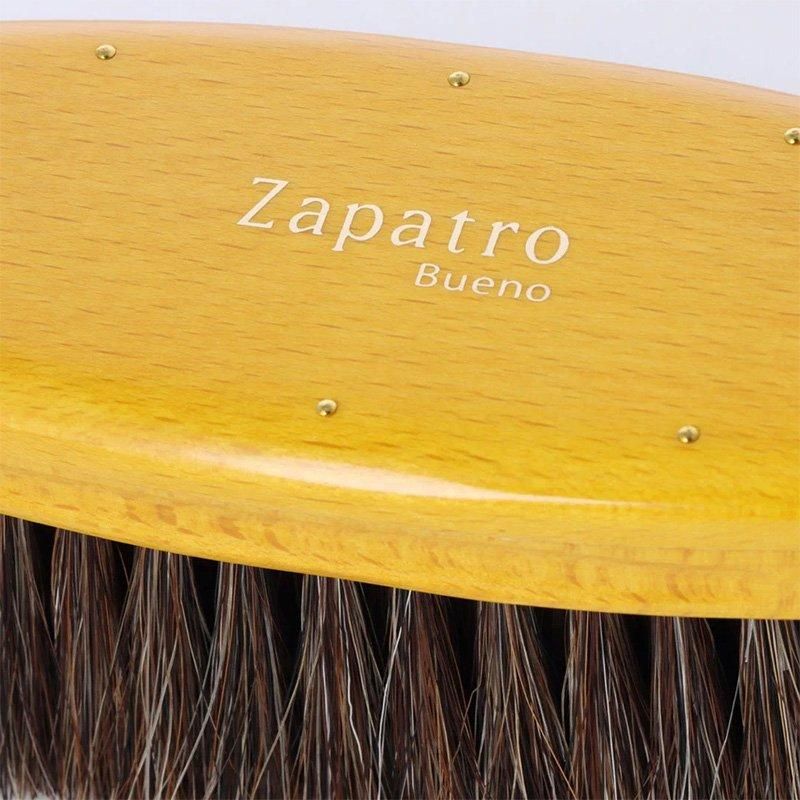 サパトロブエノの黄色いブラシの背面の拡大。金色のZapatro Buenoロゴと茶色の毛