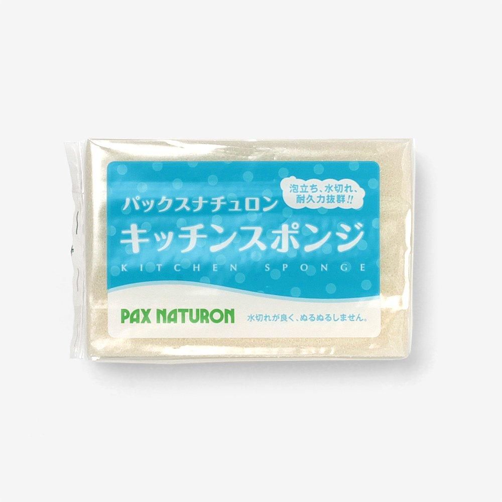 パックスナチュロン キッチンスポンジのナチュラル。水色のラベルが付いた透明袋入りの淡い色のスポンジ