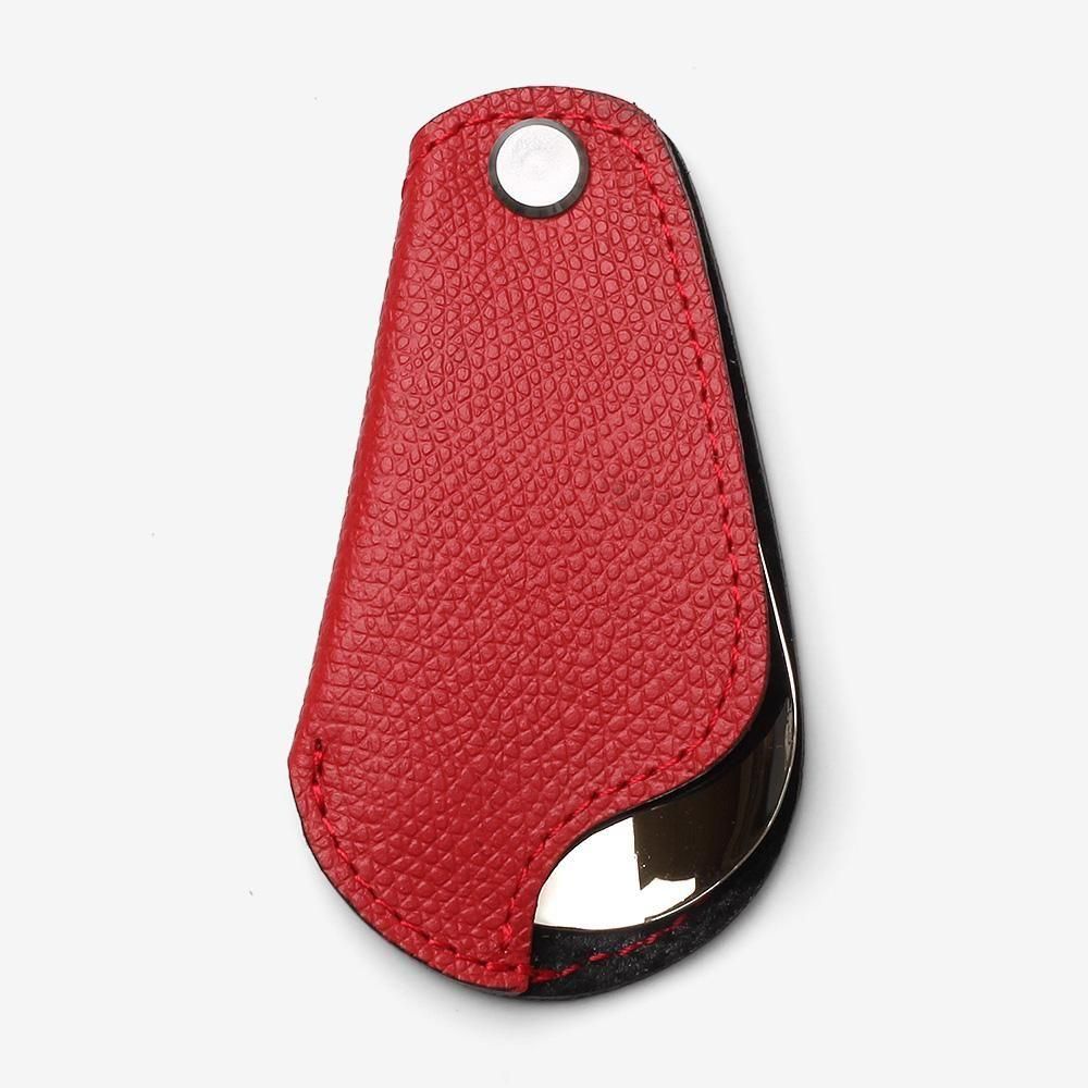 サパトロのポケットシューホーン。赤の凹凸のあるカバーに折りたたんだ状態。銀色の留め具と靴べらの先端