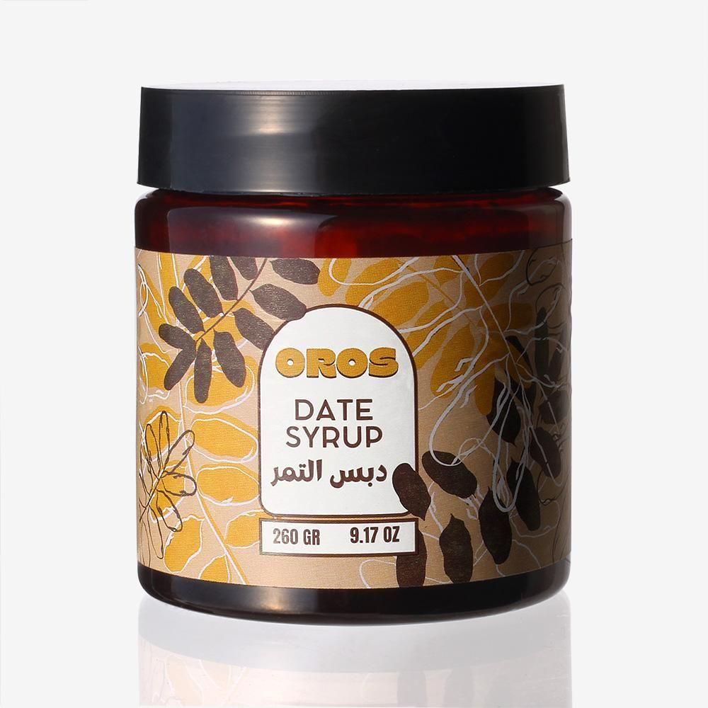 デーツシロップの黒いふた付き瓶。葉の模様のラベルにOROS、DATE SYRUP、260 GRの文字