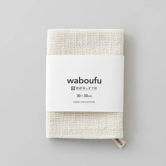 益久染織研究所 ガラ紡の和紡布30×30cm。生成りの布を畳み、waboufuの白い紙帯で包んだ状態