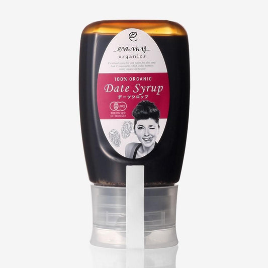 エミーオーガニクスのデーツシロップ。透明キャップを下にした濃茶色のボトルと、女性の顔を配した赤紫のラベル